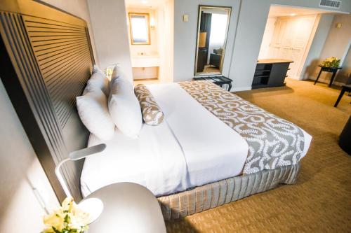 a hotel room with a large bed with white sheets and pillows at Crowne Plaza Managua by IHG in Managua