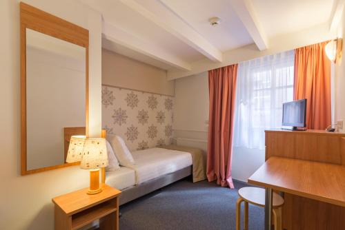 a hotel room with a bed and a mirror at Rho Hotel in Amsterdam