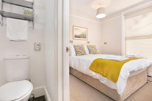 a white bedroom with a bed and a toilet at Redhouse in Salisbury