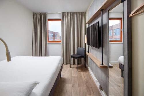 Habitación de hotel con cama y TV en ibis budget Swindon en Swindon