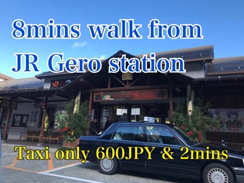 a car parked in a parking lot in front of a store at 寅家 Japanese modern hotel in Gero