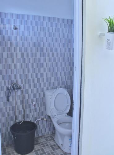 een badkamer met een toilet en een potplant bij Villa Seruni Bandungan in Bandungan