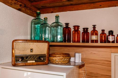 a shelf with glass bottles and a radio on it at Ferienhaus Höllberg in Hörmsdorf