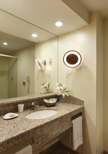 a bathroom with a sink and a large mirror at Windsor Guanabara Hotel in Rio de Janeiro