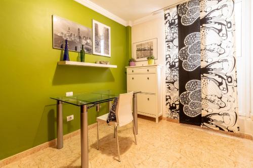 a dining room with green walls and a glass table at Flatguest Ingenio + 2 Bdr + Wifi + 4PAX in Ingenio