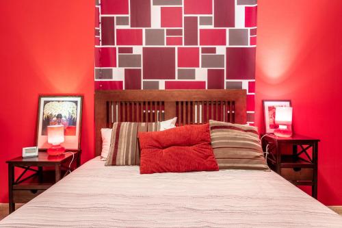 a bedroom with a bed with a red wall at Flatguest Ingenio + 2 Bdr + Wifi + 4PAX in Ingenio