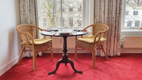 a table with two chairs and a table with glasses at Large Historical Apartment & Canal Terrace in Utrecht