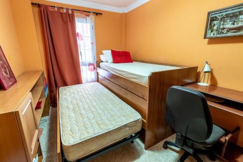 a room with two bunk beds and a desk and a chair at Flatguest Ingenio + 2 Bdr + Wifi + 4PAX in Ingenio