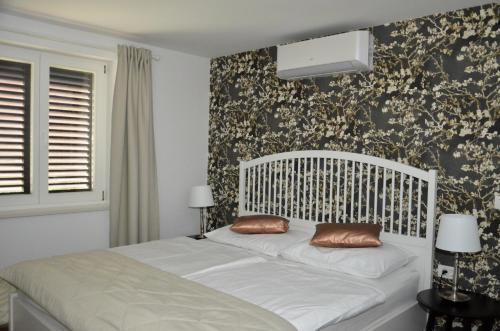 1 cama blanca con 2 almohadas en el dormitorio en Apartments Villa AnnaMaria, en Bled