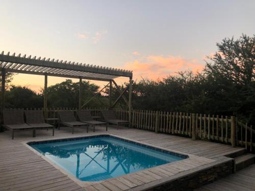 a swimming pool on a deck with a gazebo at Kgorogoro Lodge in Pilanesberg