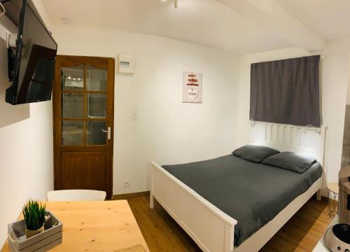 une chambre avec un lit, une télévision et une table dans l'établissement MAZZARIN STUDIO, à Aix-en-Provence