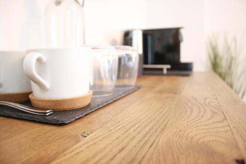 a white coffee cup on a tray on a wooden table at The Black Dog Inn in Dalton in Furness