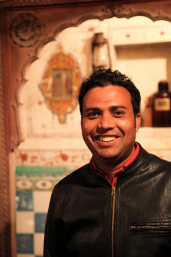 a man in a leather jacket smiling at the camera at The Prince Haveli in Bikaner