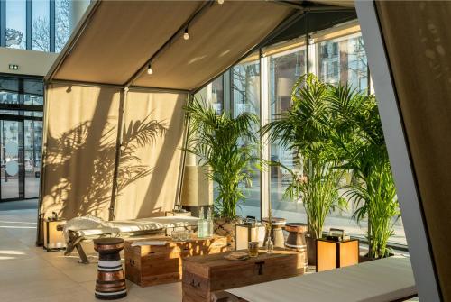 a lobby with plants and tables and windows at Novotel Paris Porte Versailles in Paris