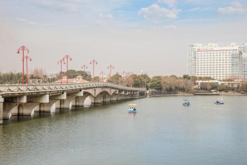 a bridge over a river with boats in the water at Crowne Plaza Nanjing Jiangning by IHG in Nanjing