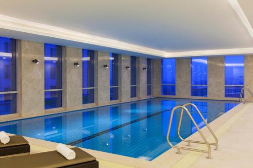 a swimming pool in a building with blue lighting at Crowne Plaza Nanjing Jiangning by IHG in Nanjing