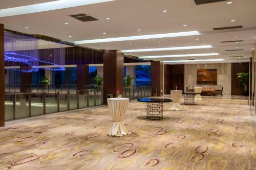a lobby with tables and chairs in a building at Crowne Plaza Nanjing Jiangning by IHG in Nanjing