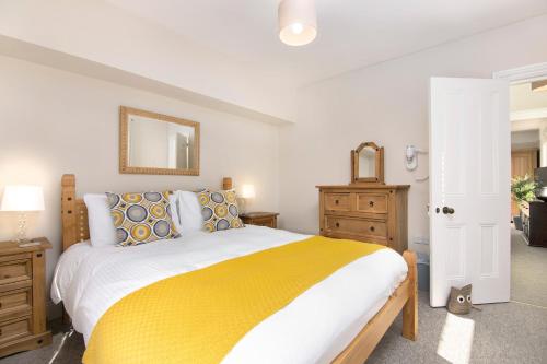 ソールズベリーにあるSalt Lane Apartmentsのベッドルーム1室(大型ベッド1台、黄色い毛布付)