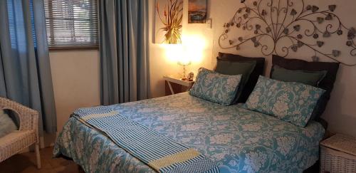 a bedroom with a bed with a blue comforter at A Farm Stay - Casablanca's Private Cottage,no loadshedding! in Hazyview