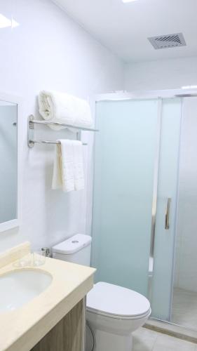 a white bathroom with a toilet and a sink at Hampton Suites in Davao City