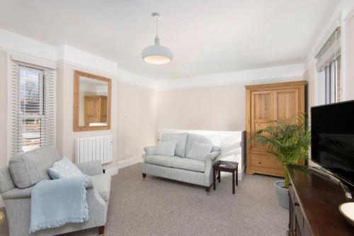 a living room with two chairs and a tv at Salt Lane Apartments in Salisbury