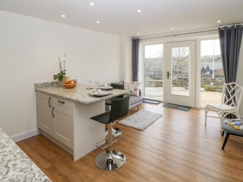 a kitchen with a counter and a table and chairs at 1 Barn Cottages in Halifax