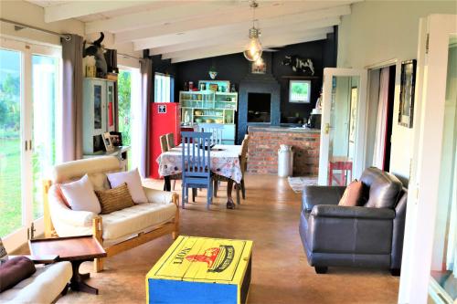 a living room with couches and a table at Round Here Self-Catering Holiday Home in Sabie