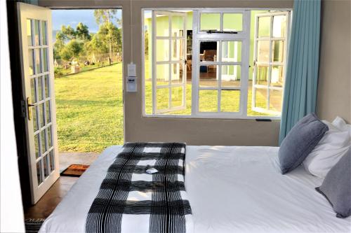 a bedroom with a bed and a door with a window at Round Here Self-Catering Holiday Home in Sabie