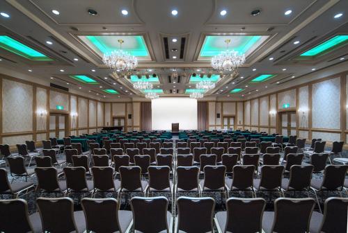 an empty banquet hall with chairs and a screen at ANA Crowne Plaza Matsuyama by IHG in Matsuyama
