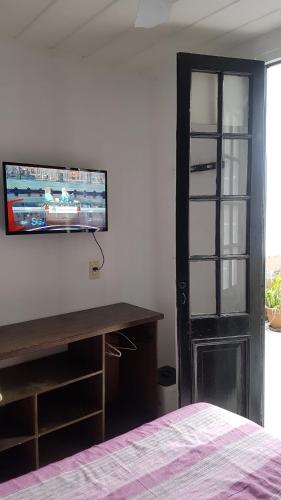 um quarto com uma secretária e uma televisão na parede em Hostel Carlos Gardel em Buenos Aires