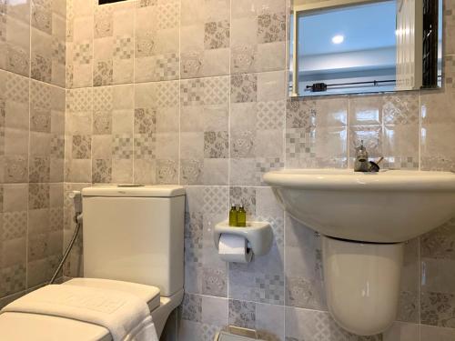 a bathroom with a toilet and a sink at โรงแรมกอดหมอน in Nakhon Pathom