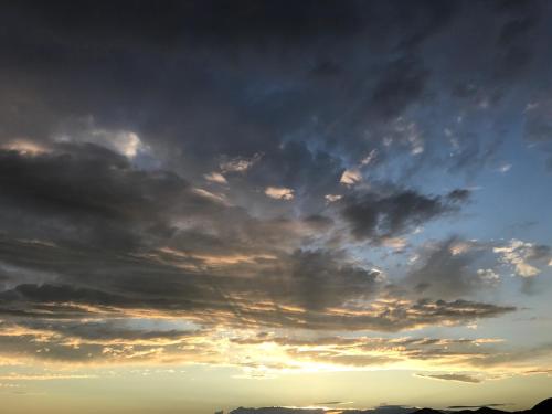a cloudy sky with the sun setting in the background at Le Storie di Manarola in Manarola