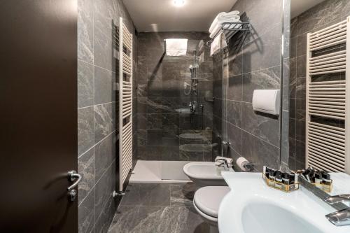 a bathroom with two toilets and a sink and a shower at Smart Hotel Holiday in Mestre