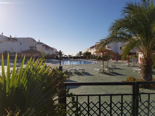 ein Resort mit einem Pool, Palmen und Gebäuden in der Unterkunft Apartamento Naturista en primera línea en Natura World! in Vera