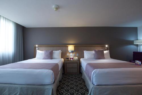 a hotel room with two beds and a window at Crowne Plaza Hotel Mexico City North-Tlalnepantla by IHG in Mexico City