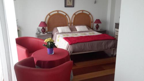 1 dormitorio con 1 cama, 1 silla y 1 mesa en Chambre d'hôtes Danielle, en San Juan de Luz