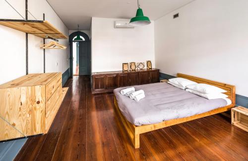 a bedroom with a bed and a wooden floor at São Miminho 3º in Porto