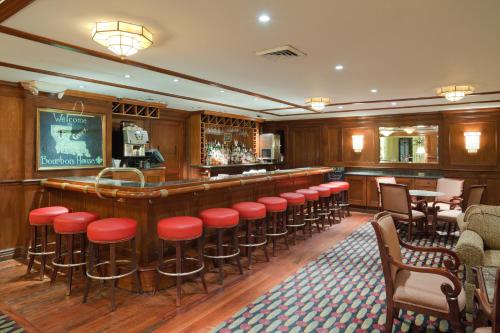 a bar with red stools in a restaurant at Crowne Plaza New Orleans French Qtr - Astor by IHG in New Orleans