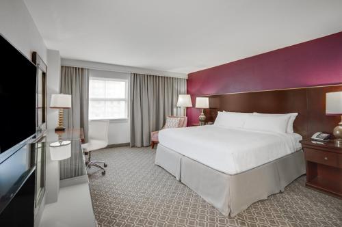 a hotel room with a large bed and a tv at Crowne Plaza New Orleans French Qtr - Astor by IHG in New Orleans