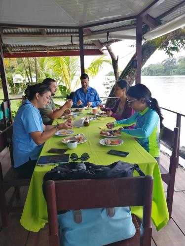 a group of people sitting at a table eating food at Chinitas Eco Lodge in Tortuguero