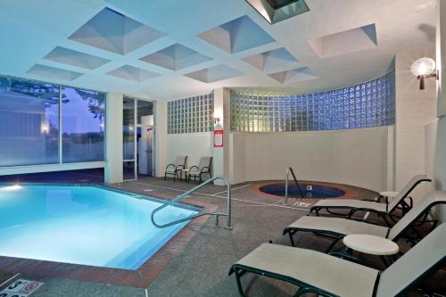 una piscina en una habitación de hotel con mesas y sillas en Crowne Plaza Portland - Lake Oswego, an IHG Hotel, en Lake Oswego