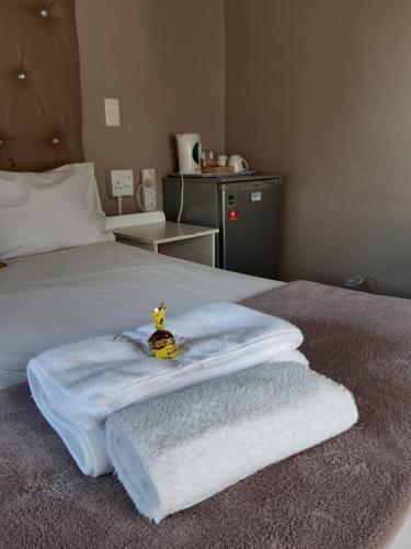 a bed with towels and a toy on top of it at Lavender Lane in Ladysmith