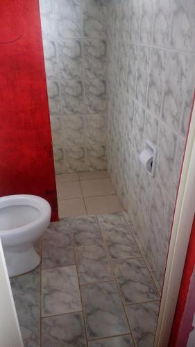 a bathroom with a toilet and a toilet paper roll at Pousada Ventania Do Rio-Mar in Joanes