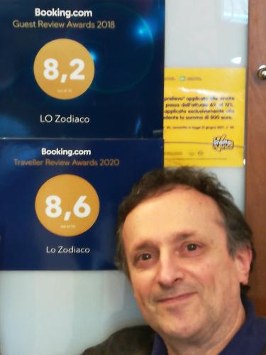 a man is standing in front of a sign at Lo Zodiaco in Roncobillaccio