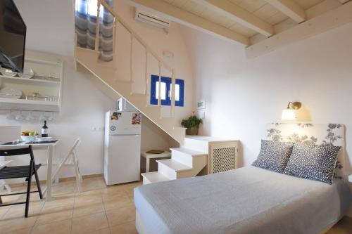a small bedroom with a bed and a staircase at Rodakas Hotel in Akrotiri