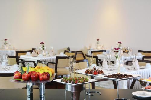a dining room with tables with plates of food at Crowne Plaza Monterrey Aeropuerto by IHG in Monterrey