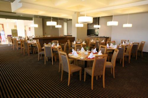a dining room with tables and chairs in a restaurant at Crowne Plaza Monterrey Aeropuerto by IHG in Monterrey