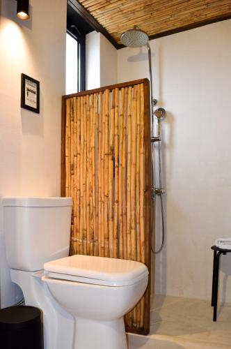 a bathroom with a toilet and a bamboo shower curtain at Kanso Rooms in Galatás