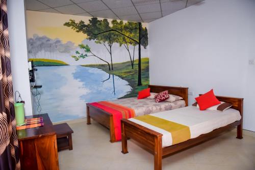 a room with two beds and a painting on the wall at Hotel Mount Valley & Yala Safari in Tissamaharama