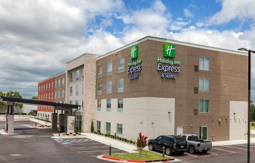 a hotel building with a truck parked in a parking lot at Holiday Inn Express & Suites Tulsa South - Woodland Hills by IHG in Tulsa